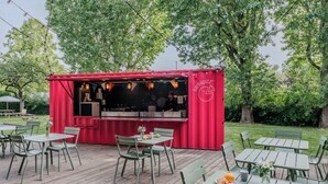 Bar rojo con terraza y zona de parrilla.