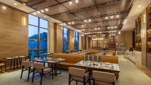 A modern restaurant with a high ceiling, large windows, and a variety of seating options including tables and sofas. - Four Points by Sheraton Hefei, Baohe (Hefei)