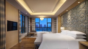 A modern hotel room with a large bed, a seating area, a TV, and a city view. - Four Points by Sheraton Hefei, Baohe (Hefei)