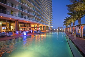 A hotel pool area with multiple levels of balconies, outdoor seating, and a clear view of the water. - Hyde Resort and Residences, OceanMiami Collection (Hollywood)