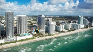 Un paisaje urbano costero con edificios altos, una playa y un cielo despejado.