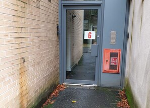 Eine Tür mit Schilder: Nummer 6, Feuermelder und Warnung vor Trockenrisiko durch Abwasser.
