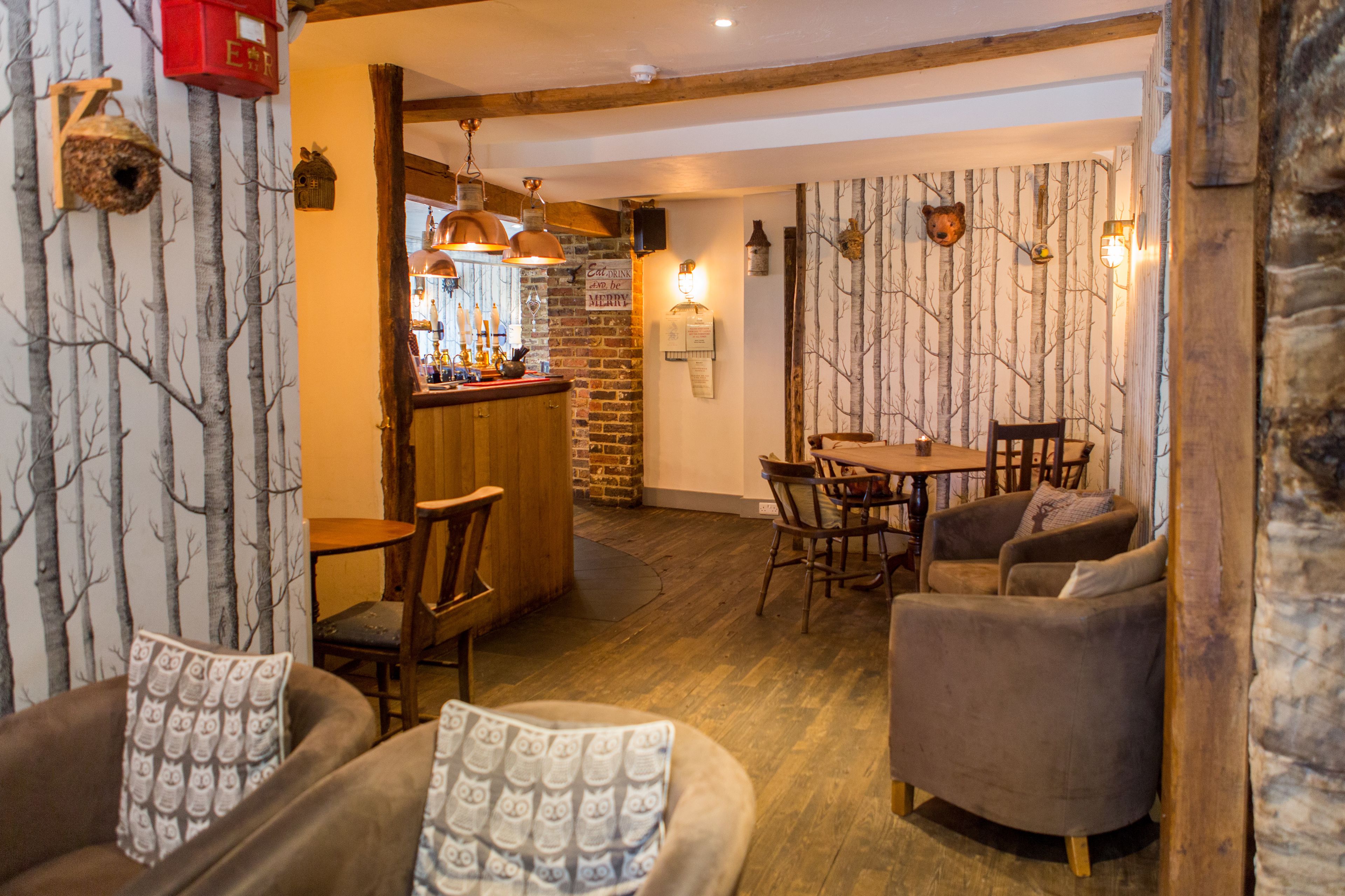 Un interior acogedor con una zona de bar, muebles de madera y decoración rústica.
