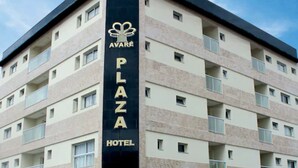 Un hotel de varios pisos con un llamativo letrero que dice 'AVARE PLAZA HOTEL' en la fachada.