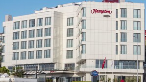 A Hampton hotel with a waterfront view, featuring a pool with sun loungers and umbrellas. - Hampton by Hilton Canakkale Gallipoli (Gallipoli)