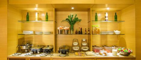 A buffet setup with various food items and condiments.