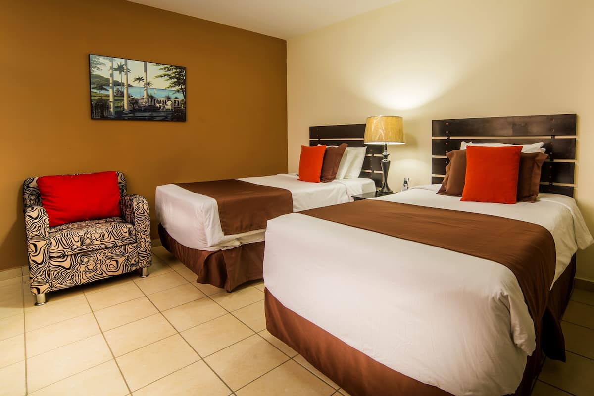 Une chambre d’hôtel avec deux lits, un canapé et un tableau au mur.
