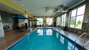 An indoor swimming pool with clear water, surrounded by seating areas and large windows. - Hampton Inn Superior Duluth (Superior)