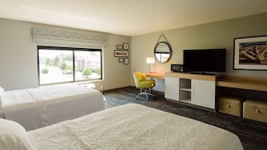 A hotel room with two beds, a desk with a television, a chair, and a window with a view of the outside. - Hampton Inn Superior Duluth (Superior)
