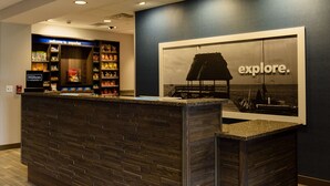 A hotel reception area with a dark wood reception desk, a large framed picture of a sailboat, and a 'Welcome to superior' sign above the reception desk. - Hampton Inn Superior Duluth (Superior)