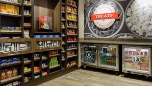 A snack and treat section with shelves stocked with various snacks and a refrigerated display case. - Hampton Inn Superior Duluth (Superior)