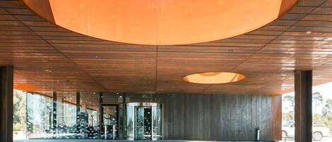 A modern building with a large circular skylight and a central garden area.