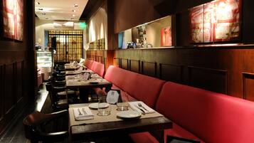 A restaurant interior with booths and tables, a bar area, and a decorative wall.