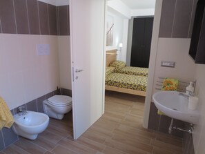 Un bagno con bidet, toilette e lavabo.