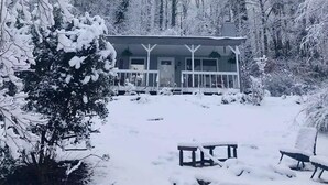 A cabin with a porch, surrounded by snow-covered trees. - Mountain Air Cabin near Franklin, Cashiers and Highlands, North Carolina (Franklin)