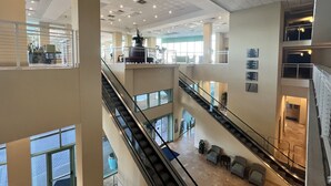 A multi-level interior with a central staircase, glass railings, and a seating area with chairs and a small table. -  Spectacular 5th floor Direct Oceanfront - lots of amenities!!- sleeps up to 7 (Panama City Beach)