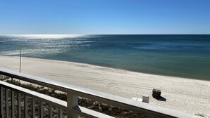 A beach view from a balcony with a railing, clear sky, and calm sea. -  Spectacular 5th floor Direct Oceanfront - lots of amenities!!- sleeps up to 7 (Panama City Beach)