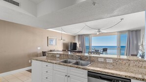 A modern kitchen with granite countertops, stainless steel appliances, and a view of the ocean. -  Spectacular 5th floor Direct Oceanfront - lots of amenities!!- sleeps up to 7 (Panama City Beach)