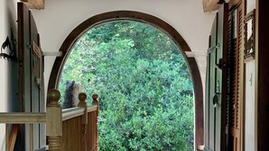 A covered walkway with a wooden railing, leading to an open archway with a view of greenery. - Unique & charming home with stunning view of Mt Washington. Pet friendly. (Jackson)