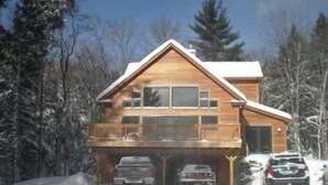A wooden cabin with a balcony, surrounded by snow-covered trees. - Stratton, Okemo, Bromley, Viking Nordic XC, Skiing!! (Londonderry)