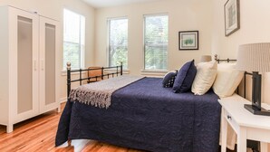 A bedroom with a bed, a wardrobe, a desk, and a window. - Downtown oasis, walking distance to Capitol, UT, Zilker Park, music venues (Austin)