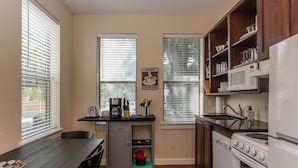 A compact kitchen with a dining table, a coffee station, and a stove. - Downtown oasis, walking distance to Capitol, UT, Zilker Park, music venues (Austin)