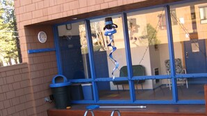 Une piscine avec un escalier, une poubelle et une porte bleue.