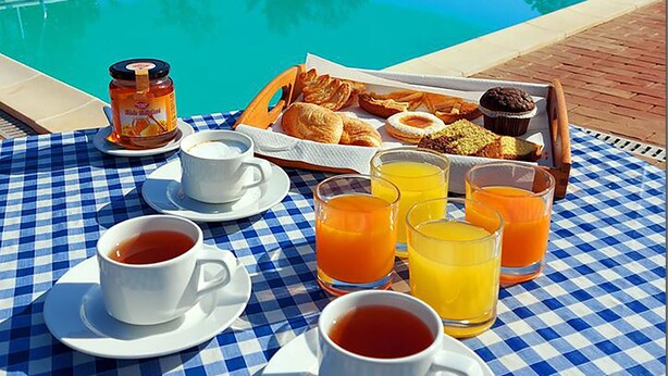 A checkered table with breakfast items, a pool, and a house in the background. - Villino Cortona - Holiday home with private pool, wifi, a/c - Tuscany (Cortona)