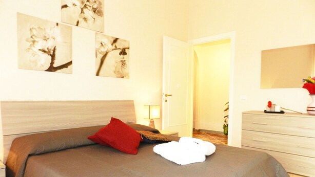 A bedroom with a bed, a nightstand, a lamp, a dresser, and wall art. - Anthony's Home 5 people (Roma)