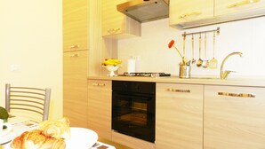 A modern kitchen with wooden cabinets, a black oven, and a stainless steel sink. - Anthony's Home 5 people (Roma)