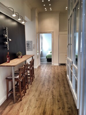 Una cocina moderna con encimera de madera, taburetes de bar y una estantería para vinos.