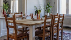 A dining room with a large wooden table, six chairs, a chandelier, potted plants, and a large mirror. - Grandiose 3BR § 3BathR apt, middle of downtown. Back and better than ever! (Budapest)