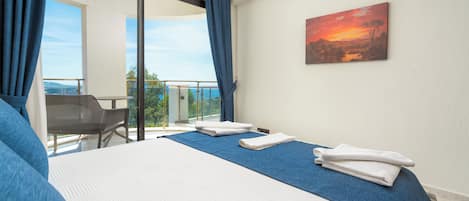 Una habitación de hotel con una cama, un cuadro y vistas al exterior.