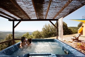 A hot tub with a view of the countryside.