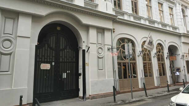 Un edificio histórico con un gran portón negro, ventanas en arco y un cartel que indica los números de habitación 7 a 9.