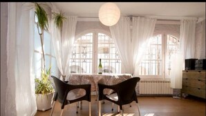 Comedor con mesa, sillas y una planta en maceta.