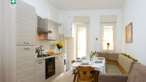 A modern kitchen with a dining area, a sofa, and a window with a view. - GREGORY BIG FAMILY (Roma)