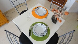A dining table set with plates, cutlery, and a glass.