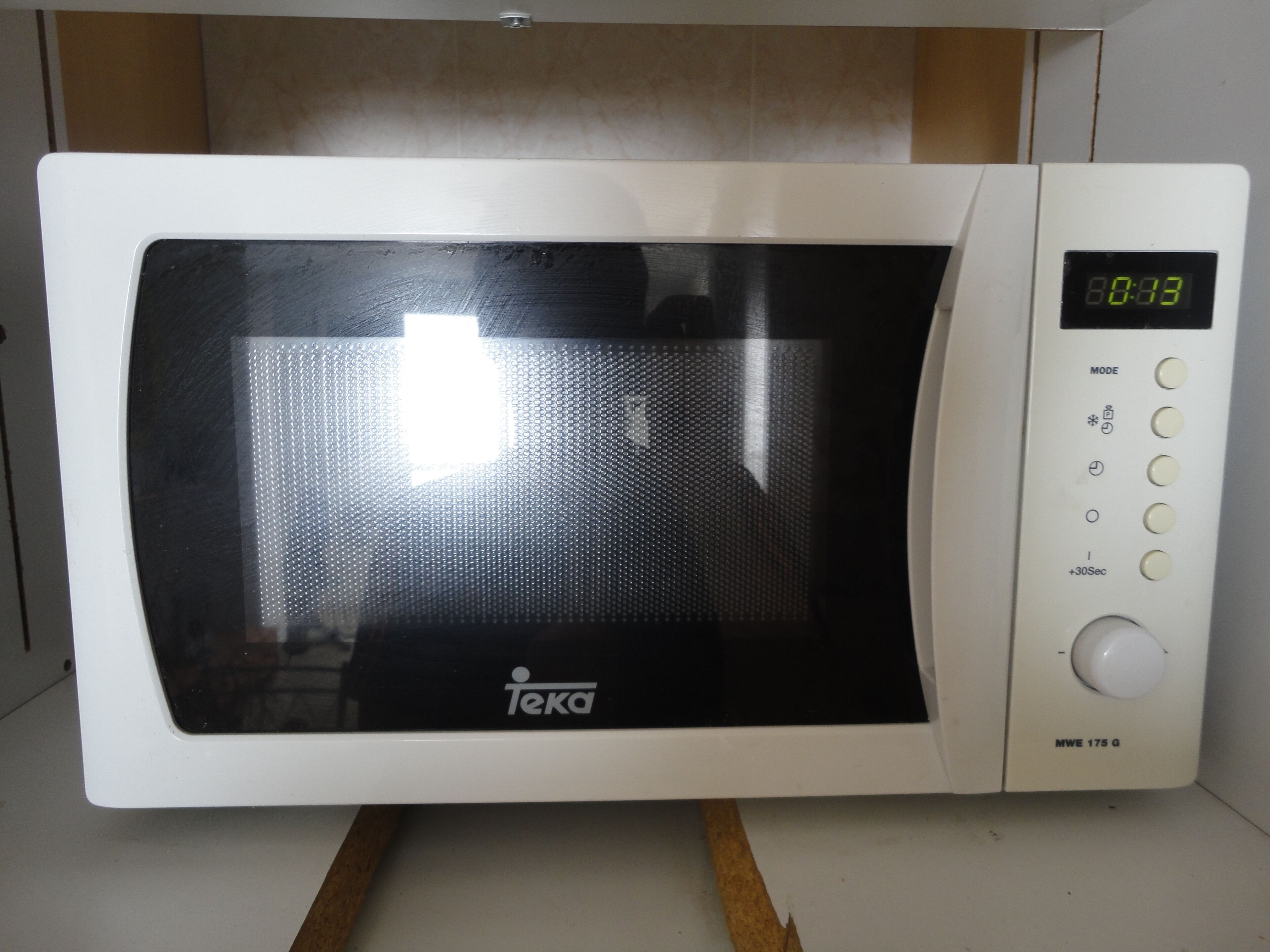 A white microwave oven with a digital display, brand name, and control buttons.