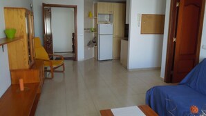 A compact living space with a kitchenette, a dining area, and a seating area.