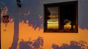 A window with a view of a sunset, a wall-mounted sign, and a wall-mounted light fixture. - Cottage on a quiet place, ideal for rest (Fuencaliente de La Palma)