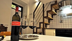 A bottle of wine and two glasses on a tray in a kitchen with a modern design, including a staircase and tiled backsplash. - Quiet luxury apartment in the middle of Rome historical center. (Roma)