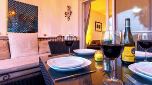 A dining area with a table set for two, featuring wine glasses, a bottle of wine, and a candle. - Front line views over the golf course (Roldan)