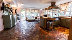 A kitchen with a brick floor, a stove, a sink, and a window overlooking a garden. - APARTMENT IN VILLA WITH POOL IN THE SALT, HEATED, SPECTACULAR VIEW !!! (SANT'OMERO)