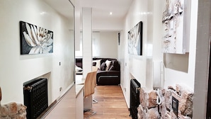 A hallway with a fireplace, a sofa, and artwork on the walls. - Holiday Rental Salamanca 4pax WIFI and PARKING / OFFERS end of season (Salamanca)