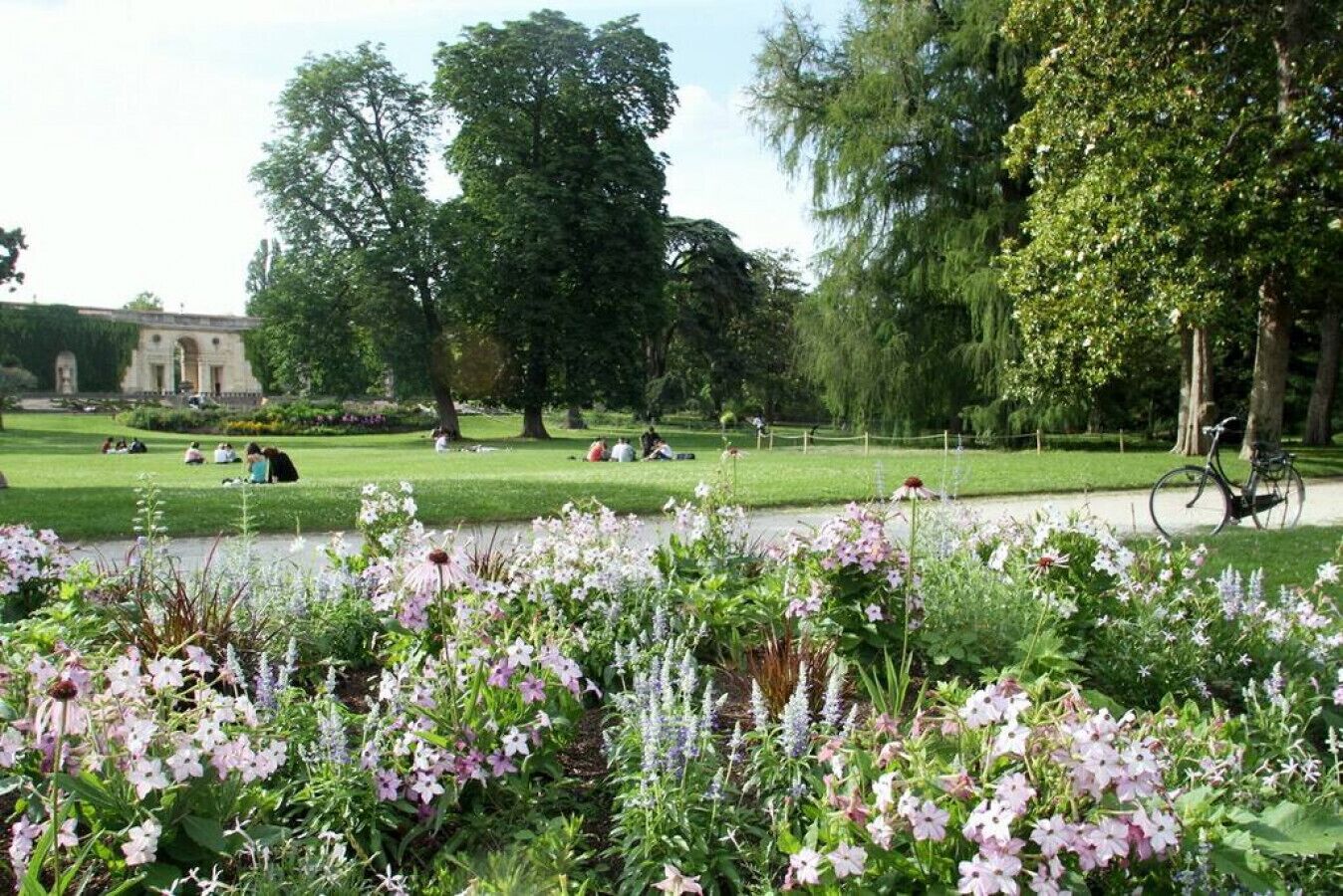 Un parc avec un étang, des bancs et un vélo.