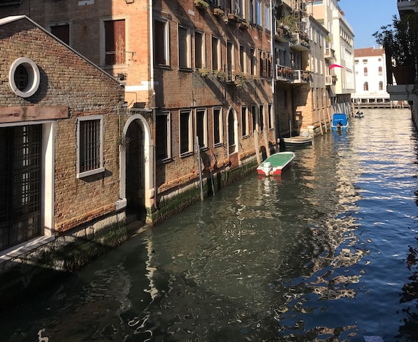A canal with buildings on one side and a boat docked on the water.