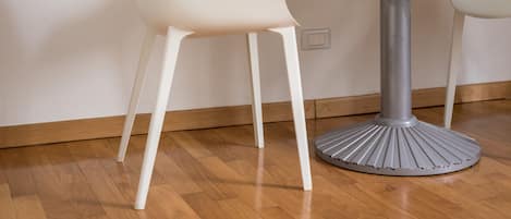 Una mesa de comedor de diseño moderno, acompañada por dos sillas blancas.