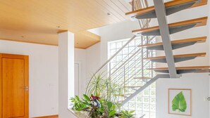 A staircase with a metal railing, a wooden door, and a plant on the landing. - Casa EmCanto - Swimming pool, games room, cinema with capacity for 16 guests (Pombal)
