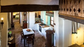 Een rustiek interieur met een eethoek, keuken en een houten trap.